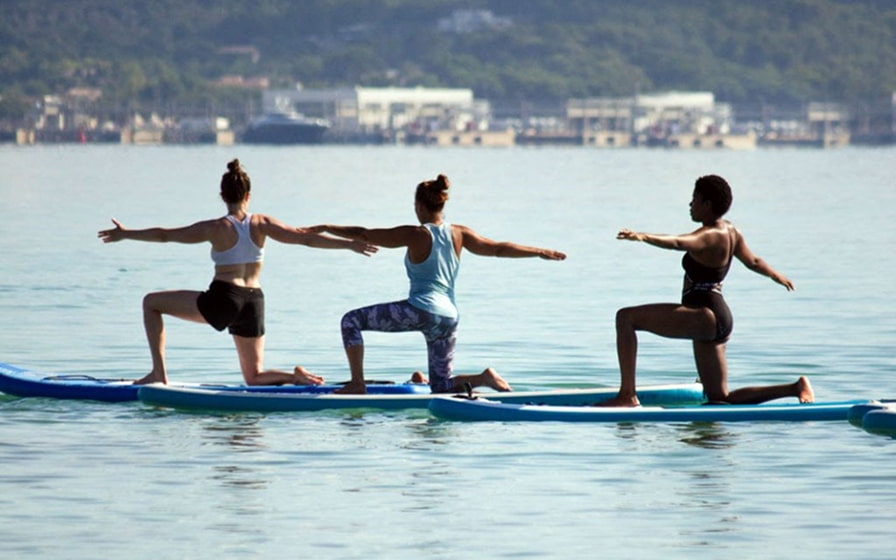 Personas haciendo yoga en el mar